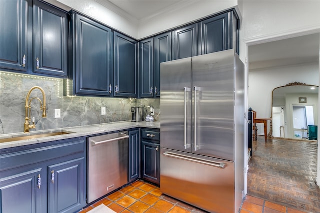 kitchen with tasteful backsplash, crown molding, blue cabinetry, sink, and appliances with stainless steel finishes