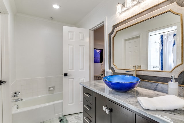 bathroom with a bathtub, vanity, and ornamental molding