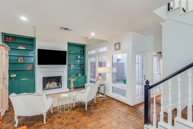 interior space with a brick fireplace, dark parquet floors, and french doors