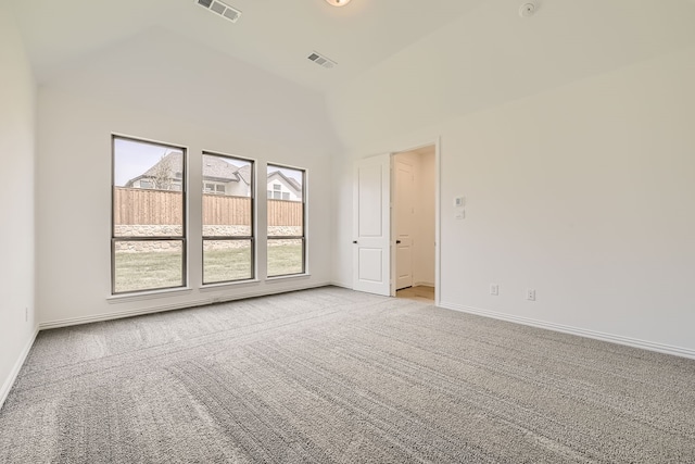 empty room featuring high vaulted ceiling and light carpet