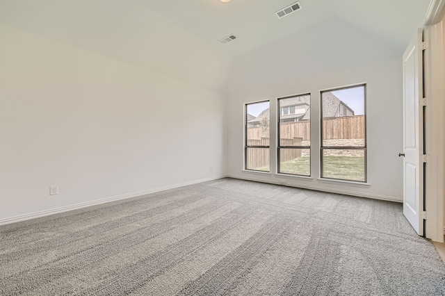 carpeted spare room with high vaulted ceiling