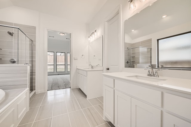 bathroom with plus walk in shower, tile patterned floors, lofted ceiling, and double sink vanity