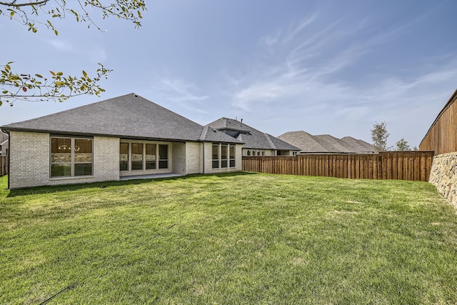 rear view of property with a lawn