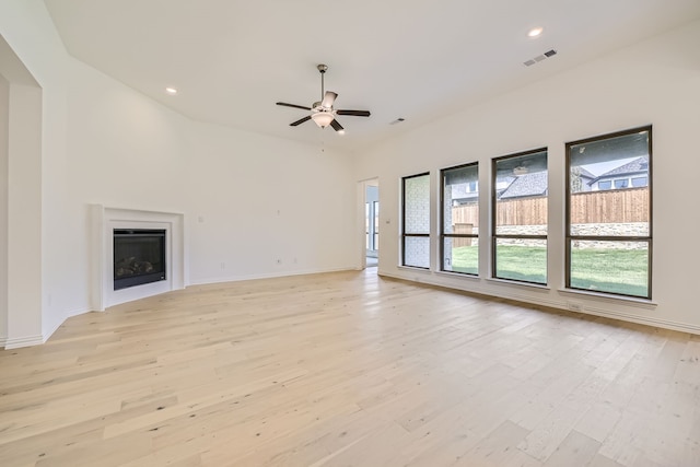 unfurnished living room featuring vaulted ceiling, ceiling fan, and light wood-type flooring