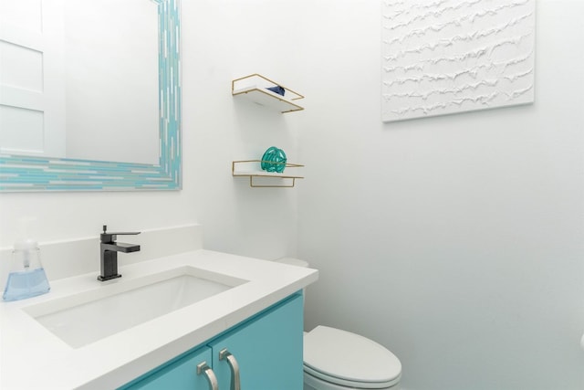 bathroom featuring vanity with extensive cabinet space and toilet