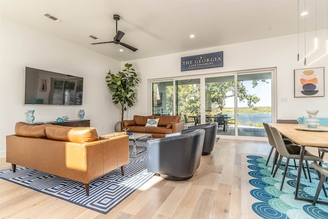 living room with light hardwood / wood-style flooring and ceiling fan