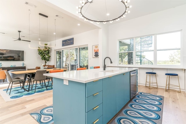 kitchen featuring a healthy amount of sunlight, light hardwood / wood-style flooring, and a kitchen island with sink