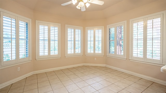 tiled spare room with a healthy amount of sunlight and ceiling fan