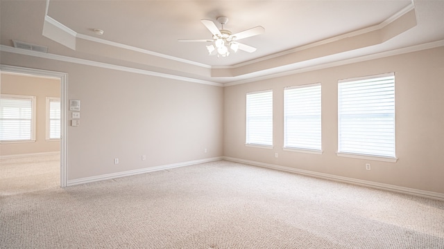 unfurnished room featuring ornamental molding, a tray ceiling, and light carpet