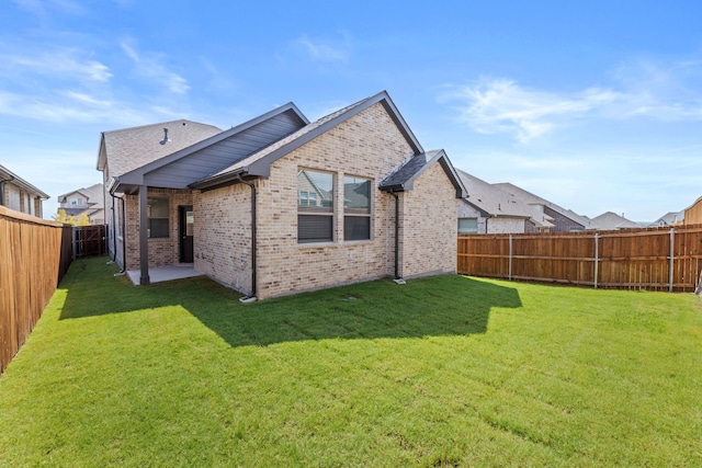 rear view of house featuring a patio and a yard