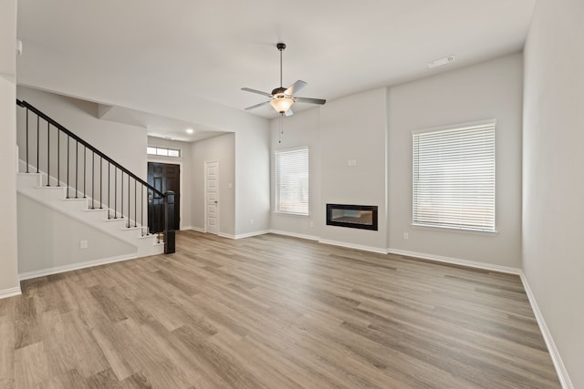 unfurnished living room with ceiling fan and light wood-type flooring