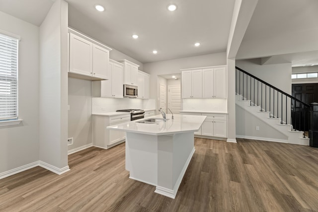 kitchen featuring hardwood / wood-style flooring, white cabinetry, sink, and appliances with stainless steel finishes