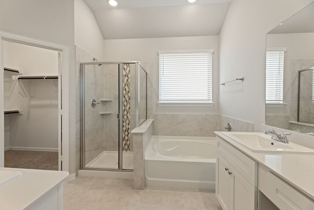 bathroom with plus walk in shower, lofted ceiling, vanity, and tile patterned floors