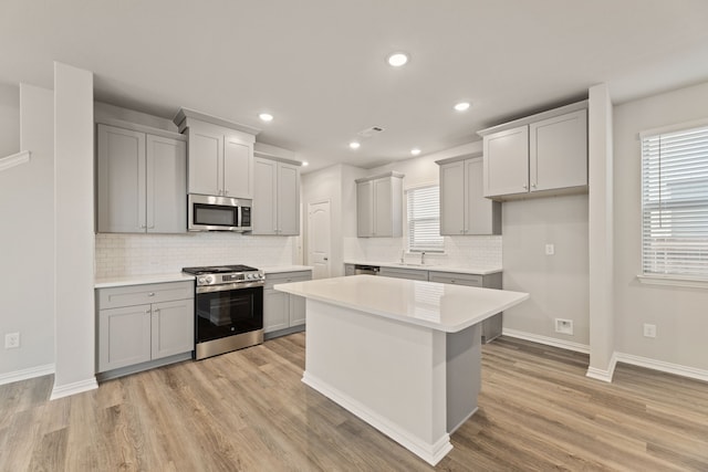 kitchen with tasteful backsplash, light hardwood / wood-style flooring, a healthy amount of sunlight, and stainless steel appliances