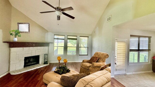 living room with a fireplace, ceiling fan, and light wood-type flooring