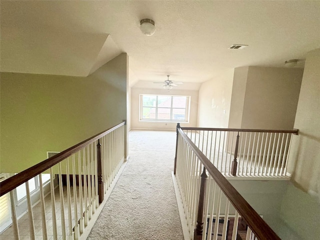 hallway with vaulted ceiling and carpet flooring