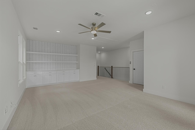 empty room featuring ceiling fan and light colored carpet