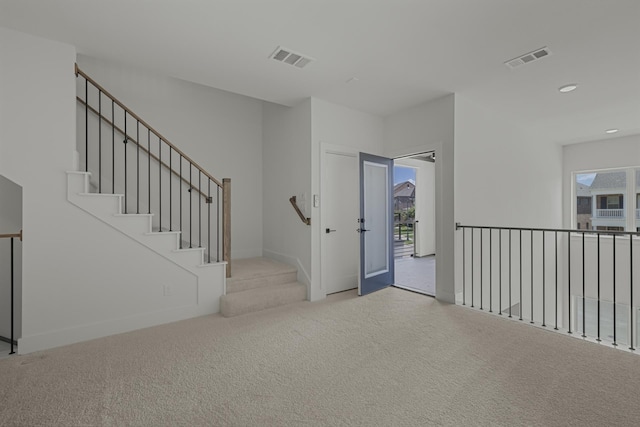 foyer entrance with light colored carpet and french doors