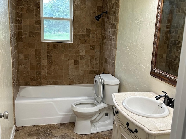 full bathroom featuring vanity, tiled shower / bath combo, and toilet