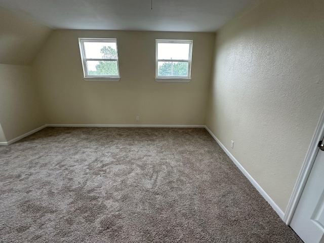 bonus room with carpet floors and vaulted ceiling