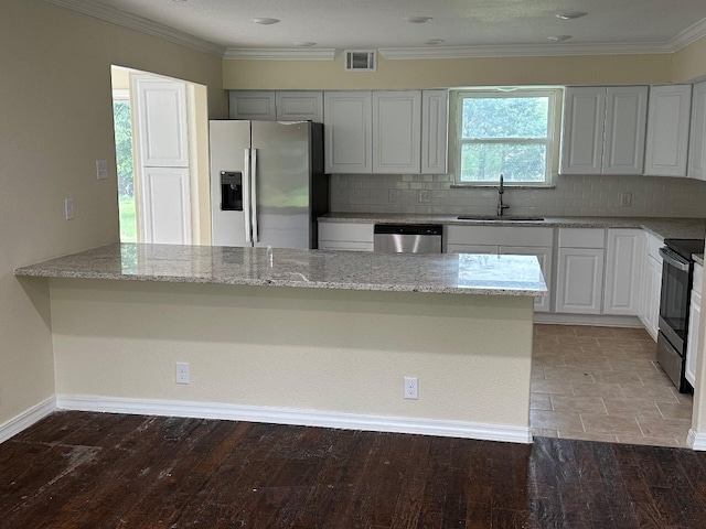 kitchen with light stone countertops, backsplash, stainless steel appliances, sink, and tile floors