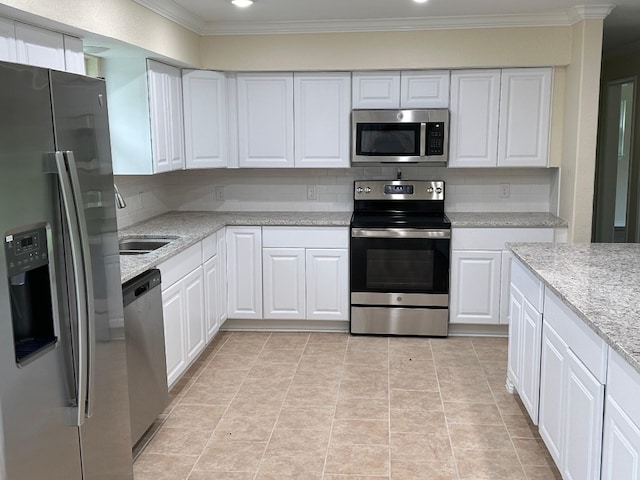 kitchen featuring tasteful backsplash, white cabinetry, and stainless steel appliances