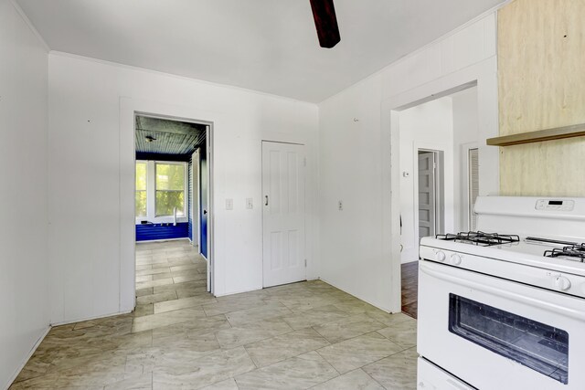 kitchen with ceiling fan, light brown cabinetry, white gas stove, and light tile floors