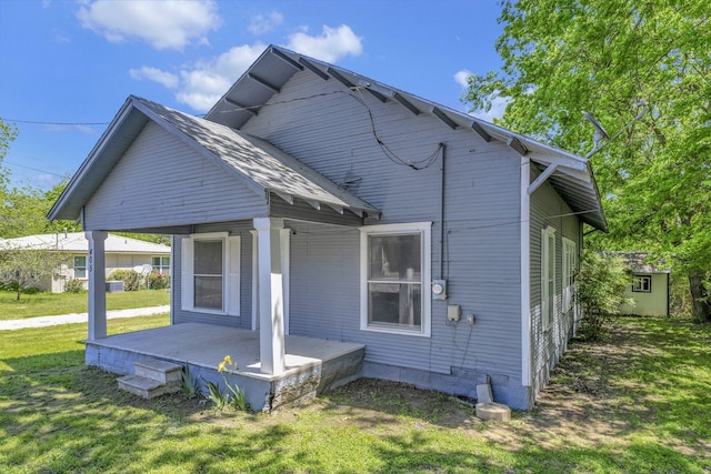 back of property with a lawn and a storage shed