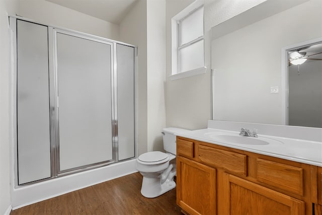 bathroom with toilet, hardwood / wood-style flooring, an enclosed shower, vanity, and ceiling fan