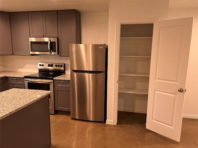 kitchen featuring stainless steel appliances and light stone counters