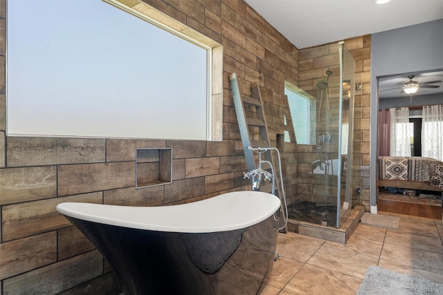 full bath with a ceiling fan, a soaking tub, tile patterned floors, a shower stall, and tile walls