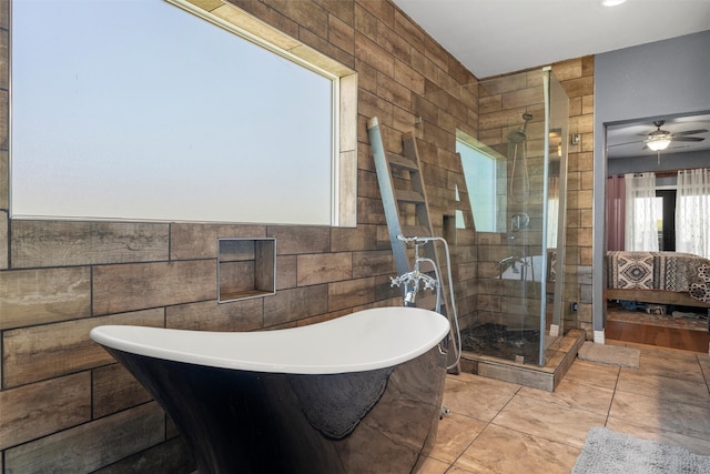 bathroom featuring tile walls, independent shower and bath, ceiling fan, and tile patterned floors