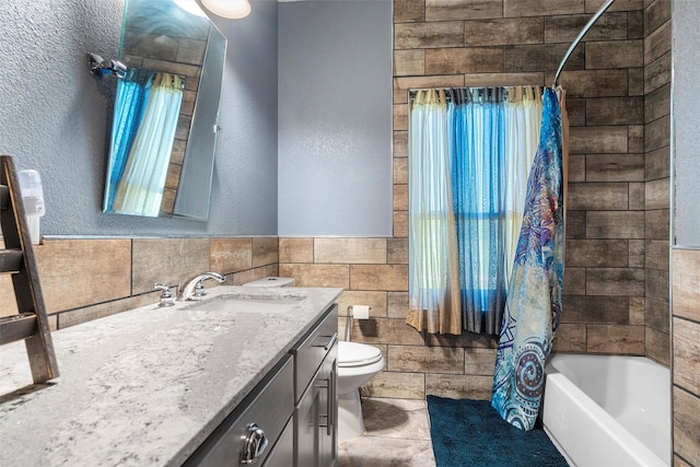 full bath featuring toilet, vanity, tile walls, plenty of natural light, and shower / bath combo with shower curtain