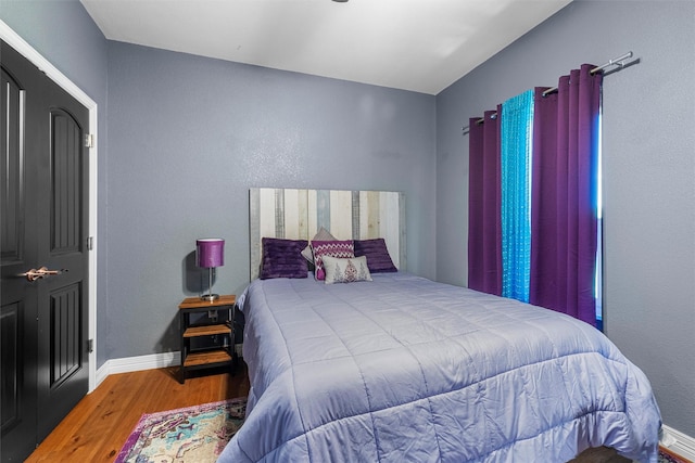 bedroom featuring baseboards and wood finished floors