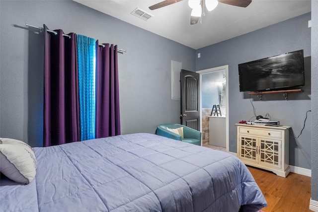 bedroom featuring visible vents, ceiling fan, baseboards, and wood finished floors