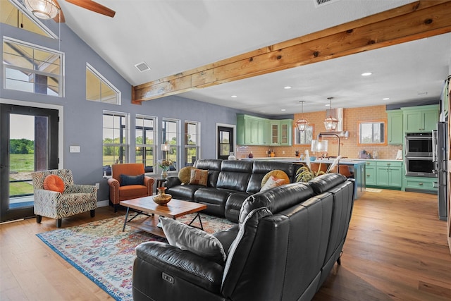 living room with beam ceiling, a healthy amount of sunlight, visible vents, and light wood finished floors