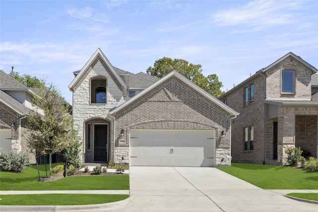 french provincial home featuring a front yard and a garage