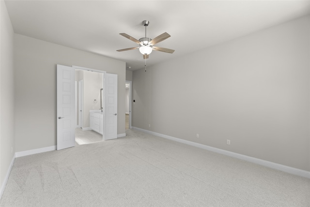 unfurnished bedroom with ceiling fan, ensuite bath, and light carpet