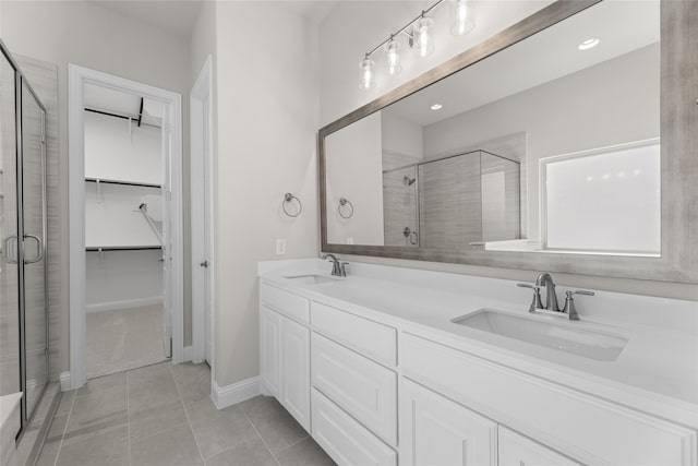 bathroom with walk in shower, vanity, and tile patterned flooring