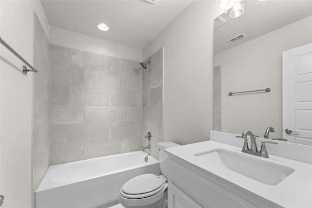 full bathroom featuring tiled shower / bath, vanity, and toilet