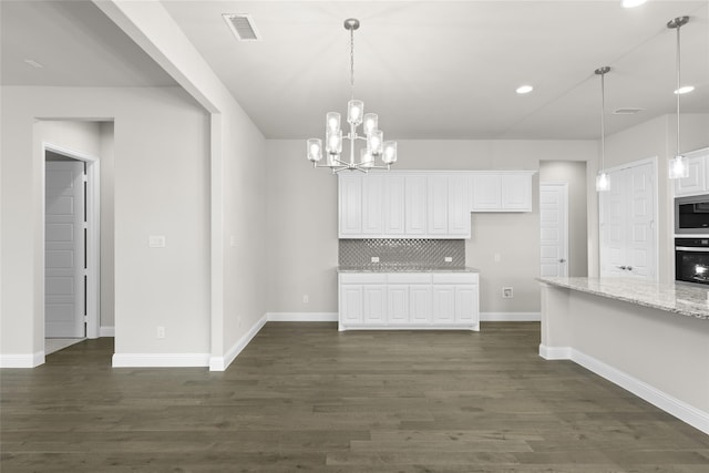 kitchen with light stone countertops, white cabinets, pendant lighting, and dark wood-type flooring