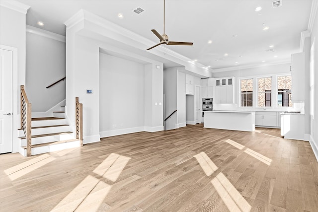 unfurnished living room featuring crown molding, light hardwood / wood-style flooring, and ceiling fan