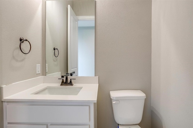 bathroom featuring vanity with extensive cabinet space and toilet