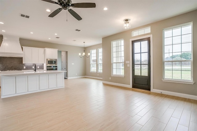 kitchen featuring white cabinets, plenty of natural light, backsplash, and custom exhaust hood