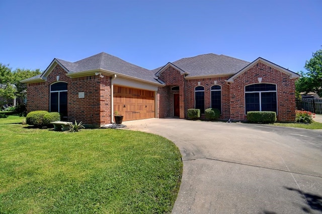 ranch-style home featuring a garage and a front lawn