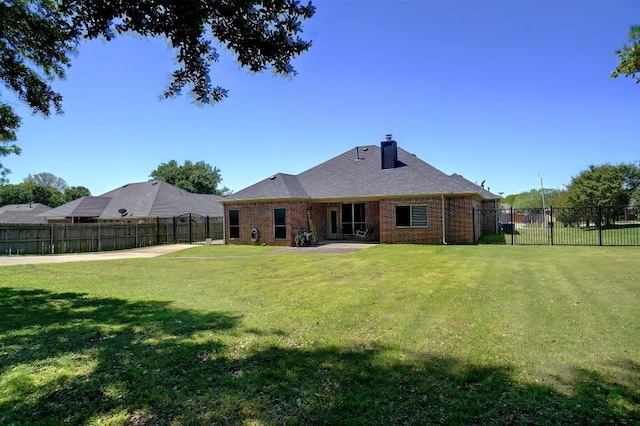 rear view of property with a patio and a lawn