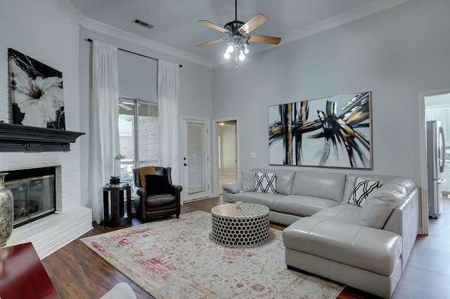 living room featuring hardwood / wood-style floors, ornamental molding, and a fireplace