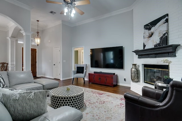 living room with ornamental molding, dark wood-type flooring, and decorative columns