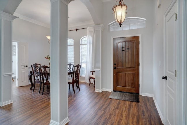 entryway featuring crown molding, dark hardwood / wood-style floors, and decorative columns