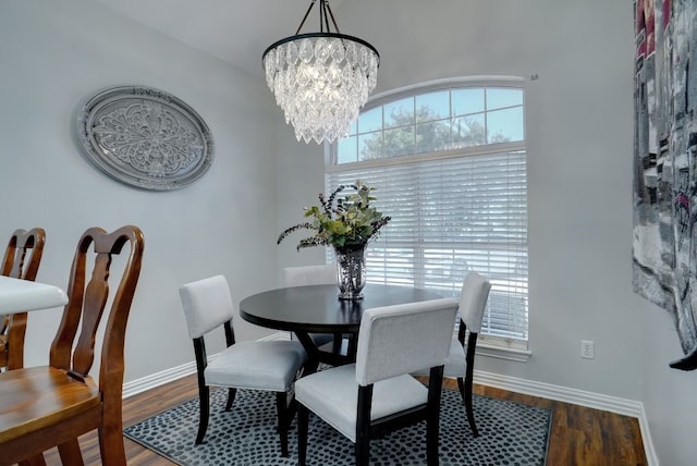 dining space featuring dark wood-type flooring and a chandelier